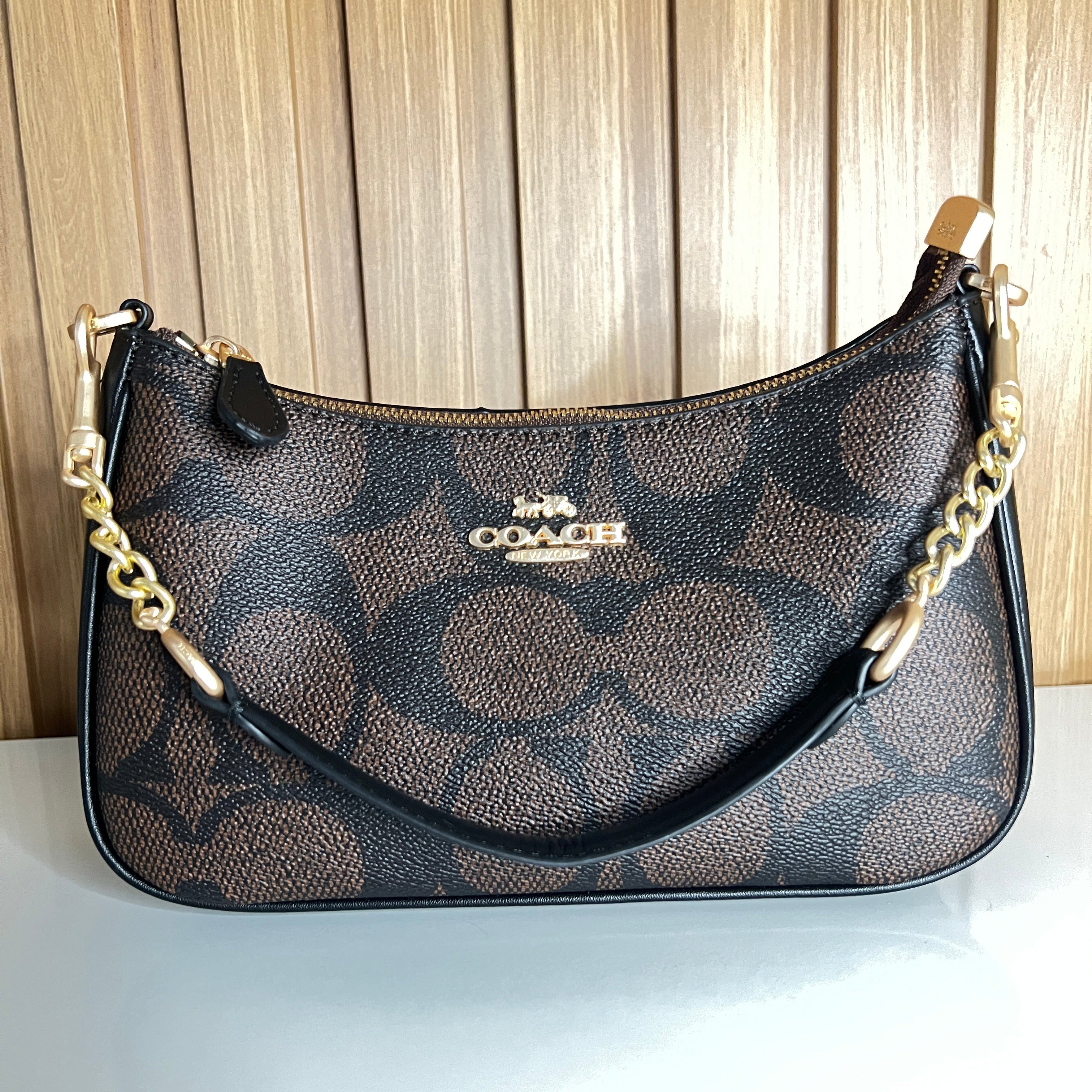 Logo Print Crescent Shoulder Bag – Brown & Black with Gold Chain Strap by Meraki by Emaan Pakistan - Front View with Mini Strap