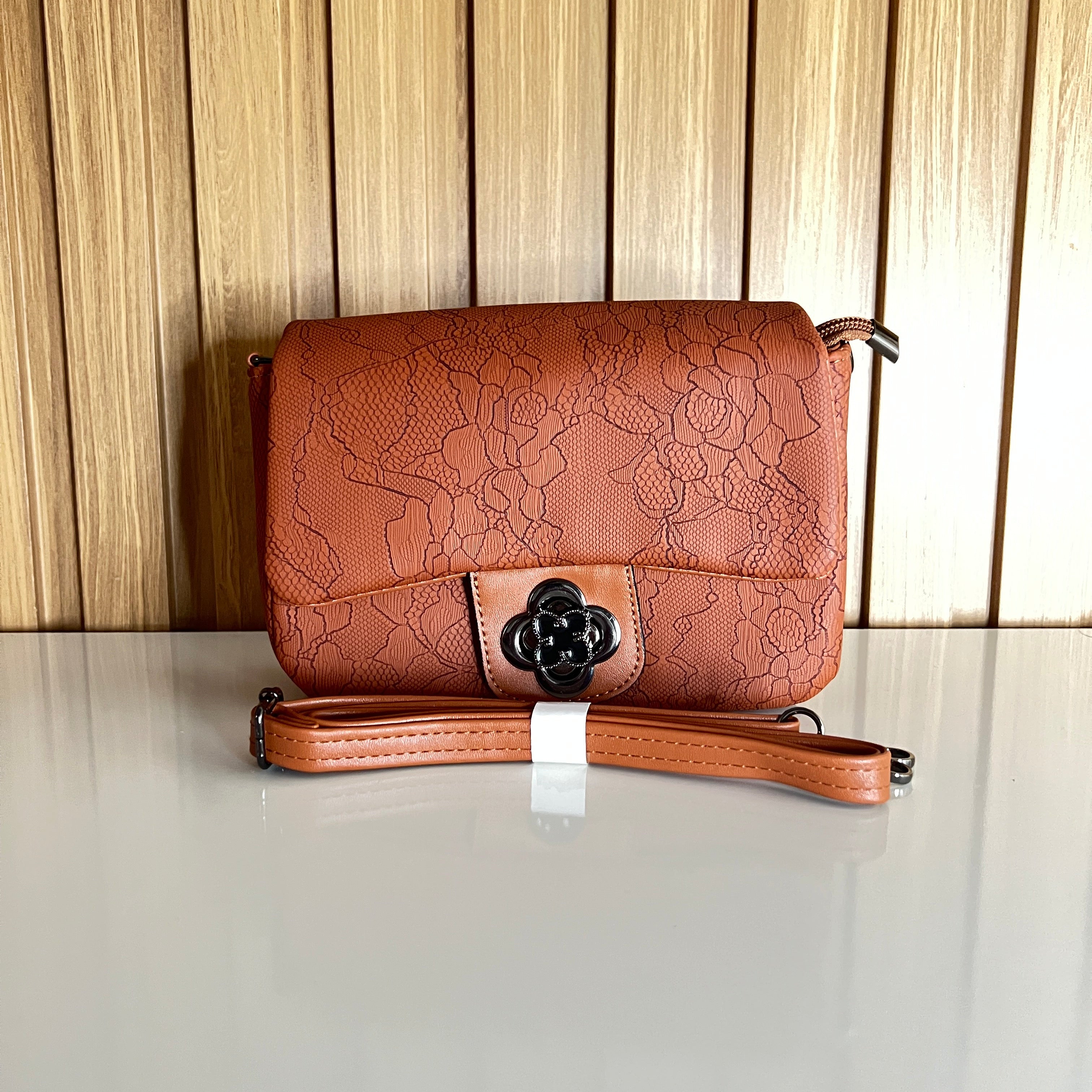 an floral embossed shoulder bag front with flower turn-lock clasp – Meraki by Emaan Pakistan