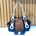 Black and brown women's handbag with white handles and decorative metal ring details