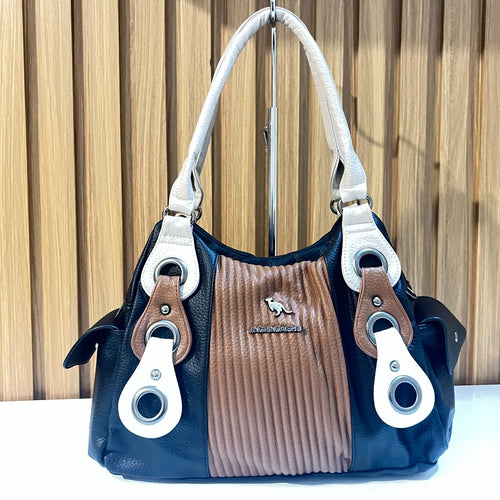 Front view of black and brown women's handbag with white handles and textured center panel