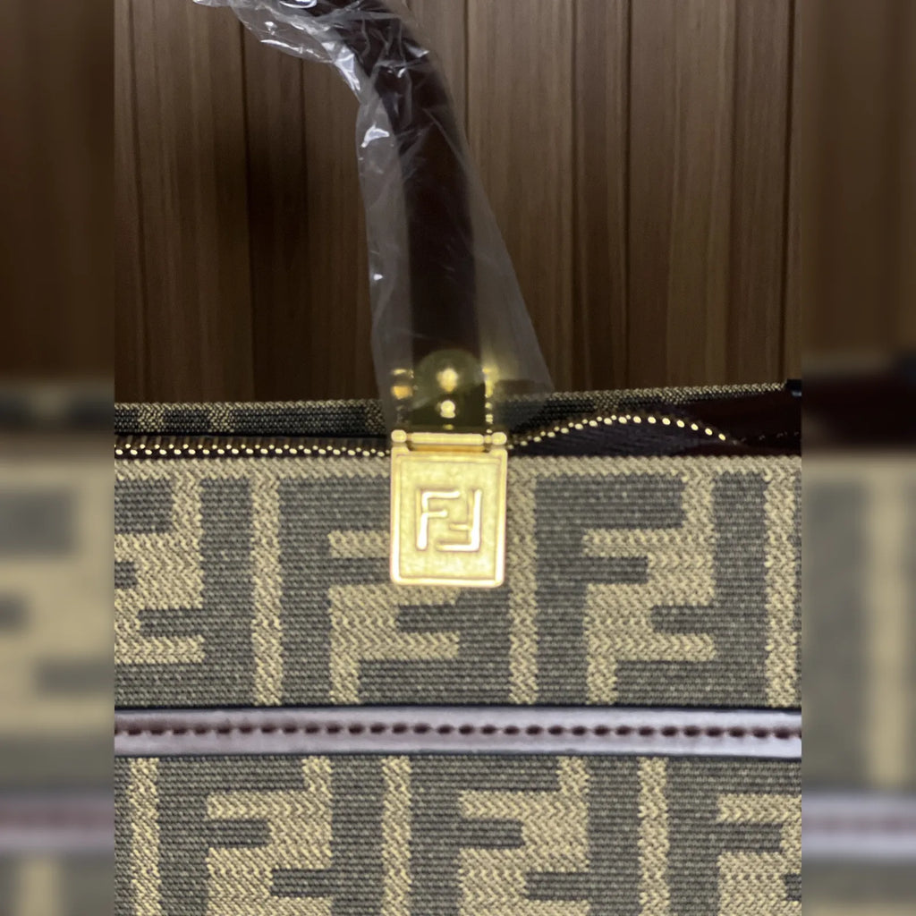 Close-up of gold-tone hardware and patterned fabric on tote bag